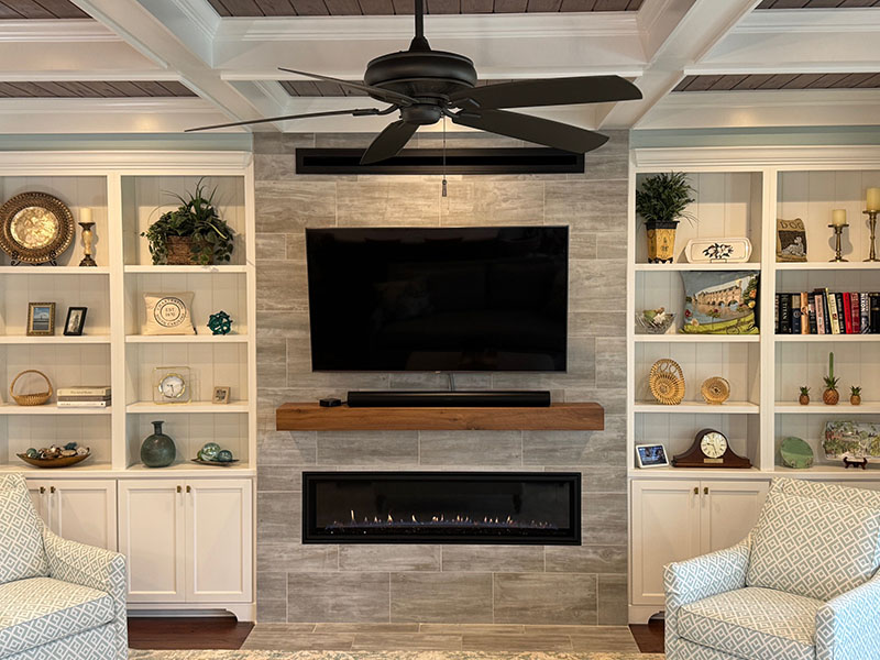 Transitional interior design by KDC Interiors — coffered ceiling, built-in shelving, and linear fireplace in a Charleston living room