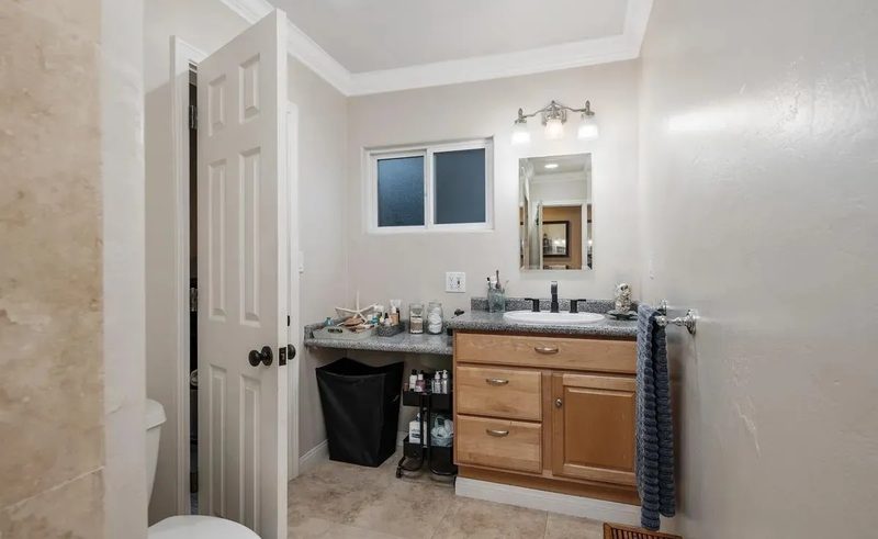 Before: the girls' bathroom with a dated oak vanity and beige tile
