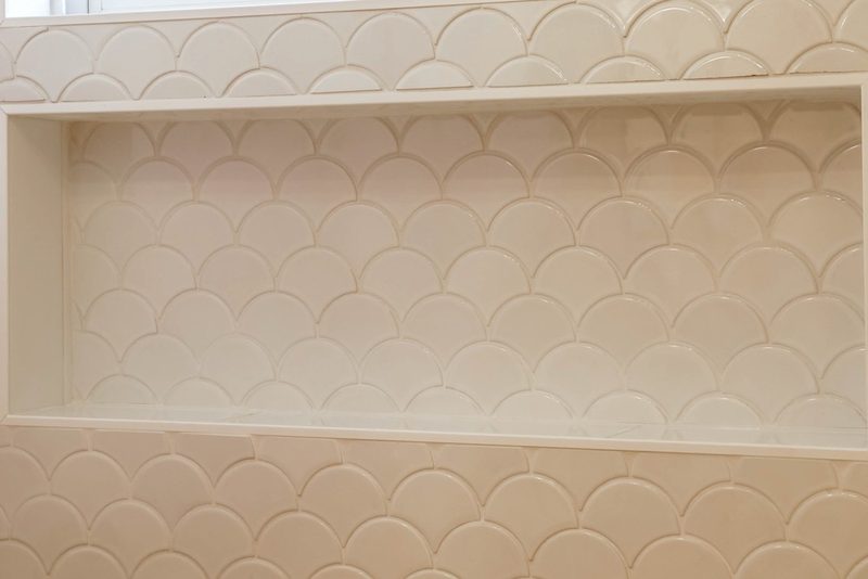 White scalloped shower tile reminiscent of mermaid scales, by KDC Interiors