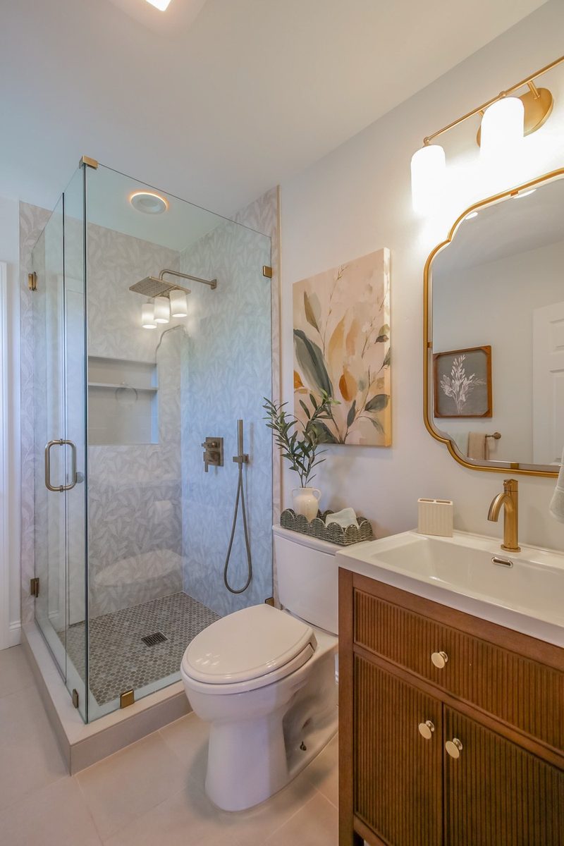 Frameless glass shower beside the reeded walnut vanity, by KDC Interiors