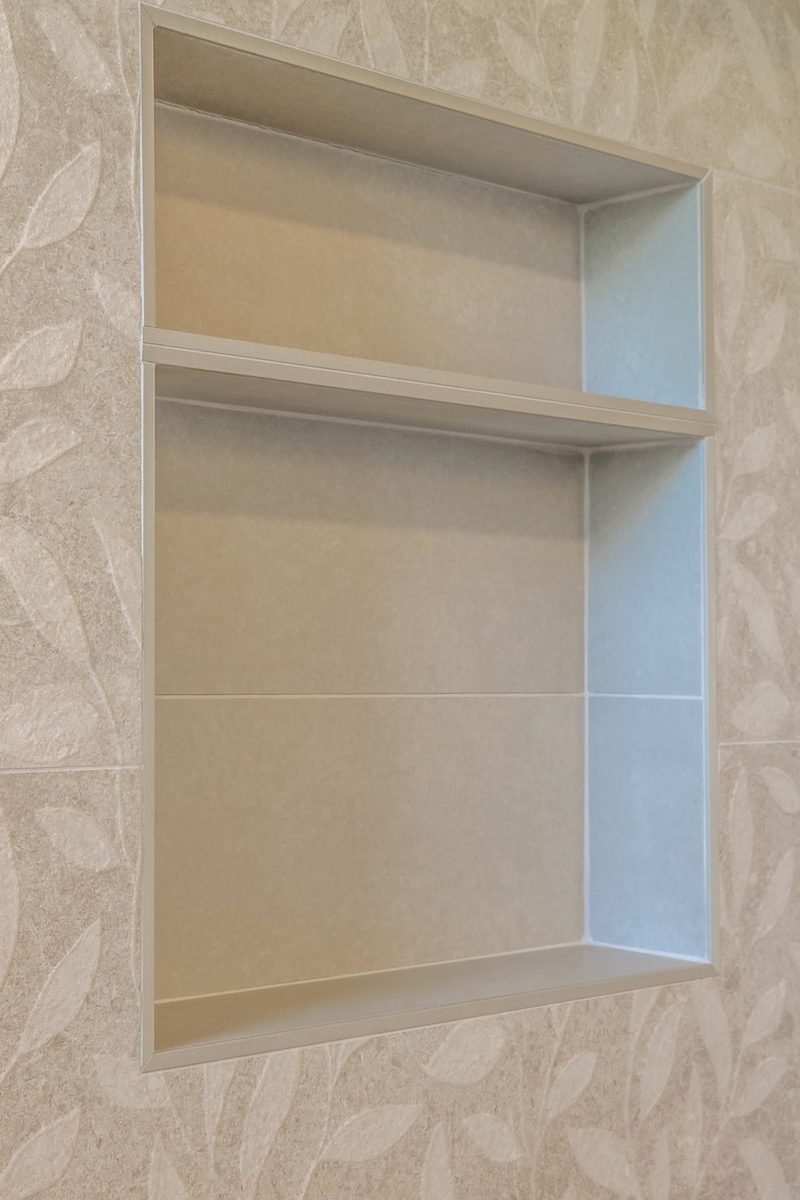 Shower niche set into leaf-pattern tile, by KDC Interiors
