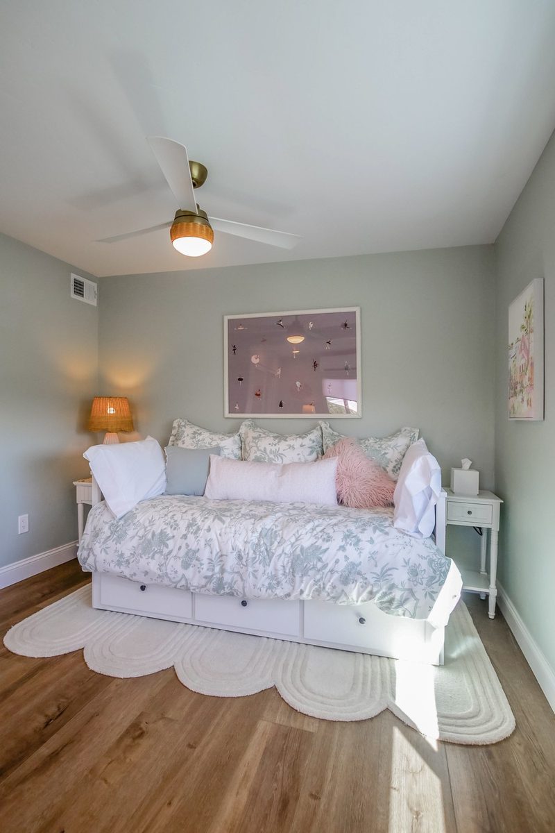 Daybed layered with pink and floral pillows, by KDC Interiors