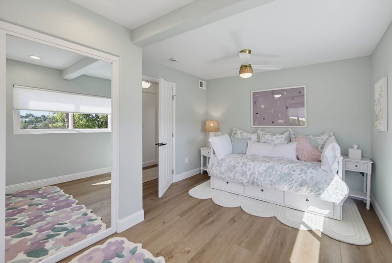 Trundle daybed with mirrored closet doors and a floral rug, by KDC Interiors