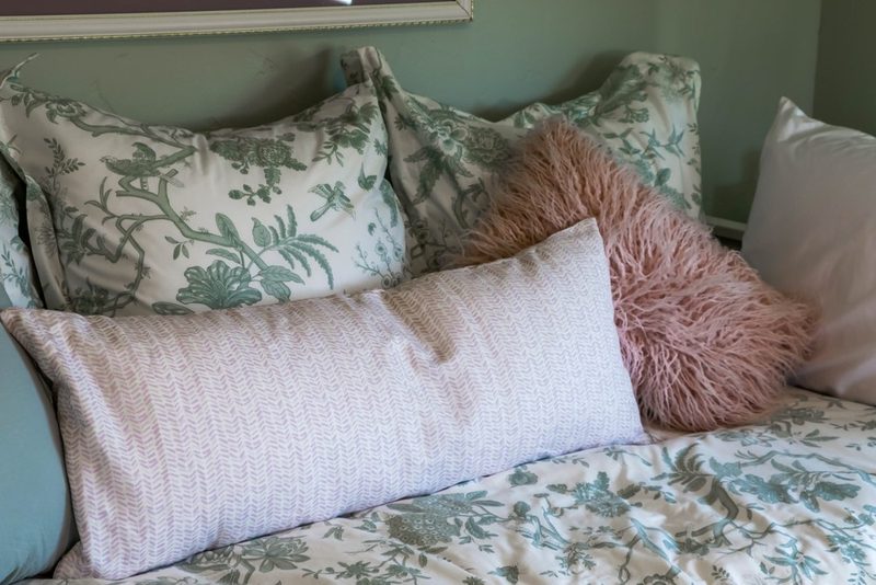 Layered pink and floral pillows, by KDC Interiors