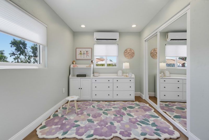 White storage dresser beside the floral rug, by KDC Interiors