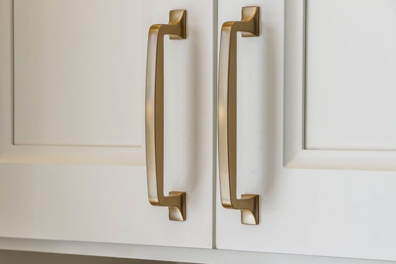 Brass cabinet pulls on white shaker doors, by KDC Interiors