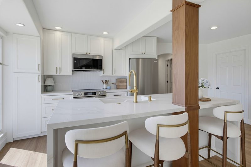 Island seating beneath the structural beam and support post that replaced the dividing wall, by KDC Interiors