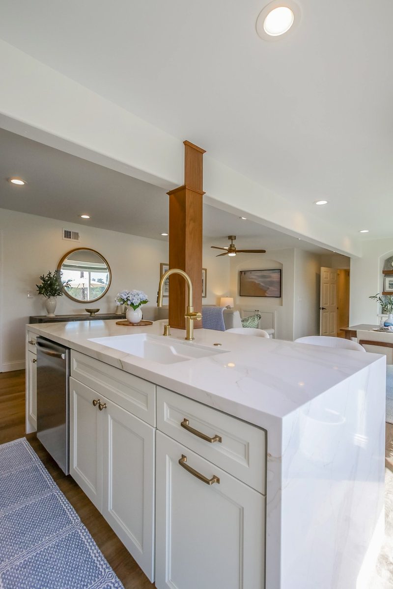 Quartz island with an undermount sink looking through to the living area, by KDC Interiors