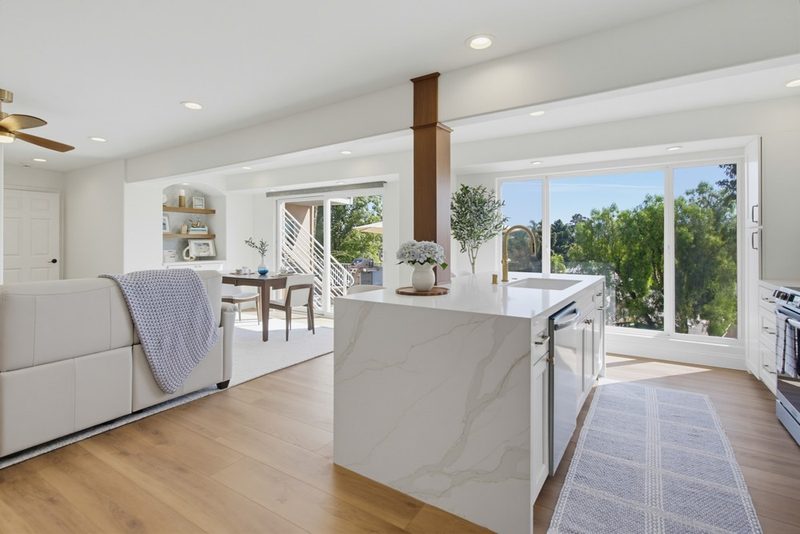 Kitchen opening onto the living area with uninterrupted outdoor views, by KDC Interiors