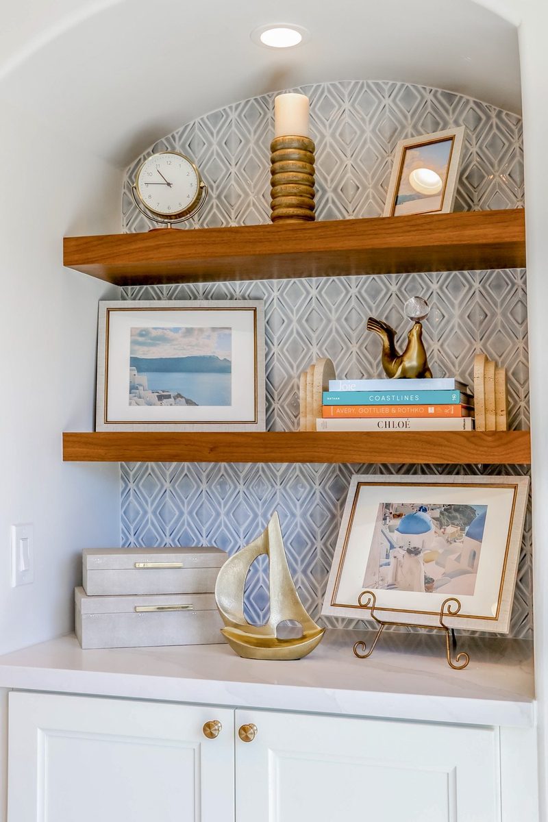 Styled built-in niche with a wallpapered back and curated shelf decor, by KDC Interiors