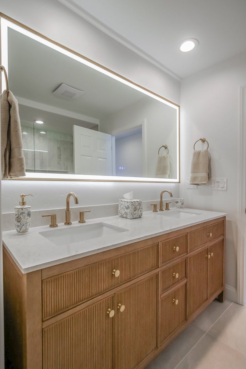 Reeded oak dual vanity with brass hardware and a quartz countertop, by KDC Interiors