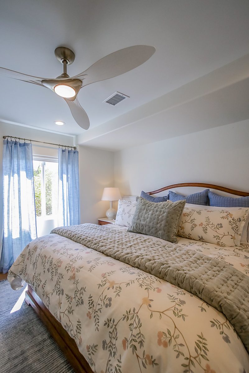 Primary bedroom with a ceiling fan and window, by KDC Interiors